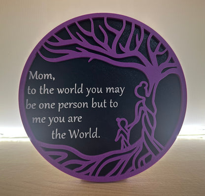 Decorative plaque with a purple border and Mom you are the world on a wooden surface