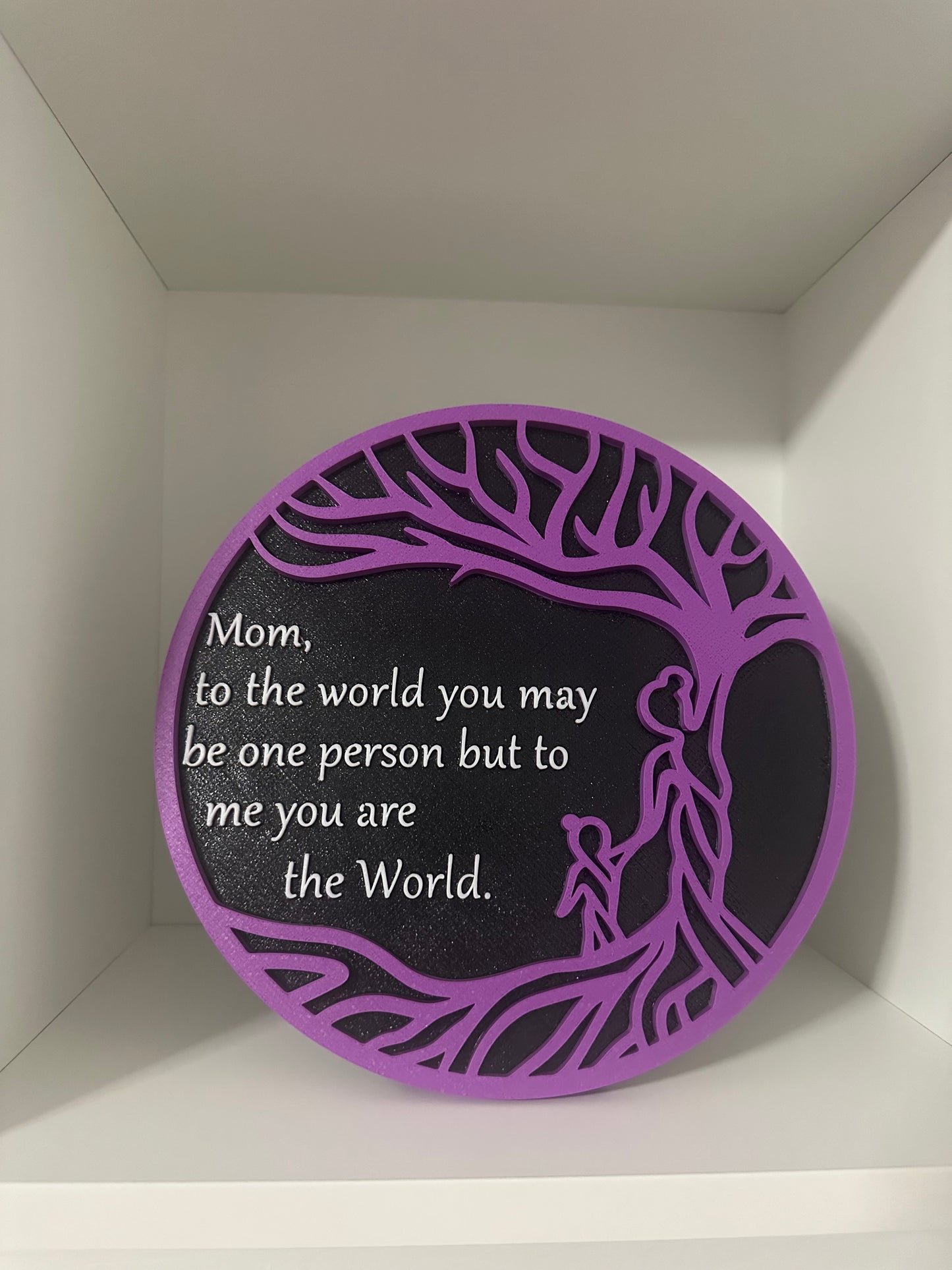 Round purple and black plate that says Mom you are the world