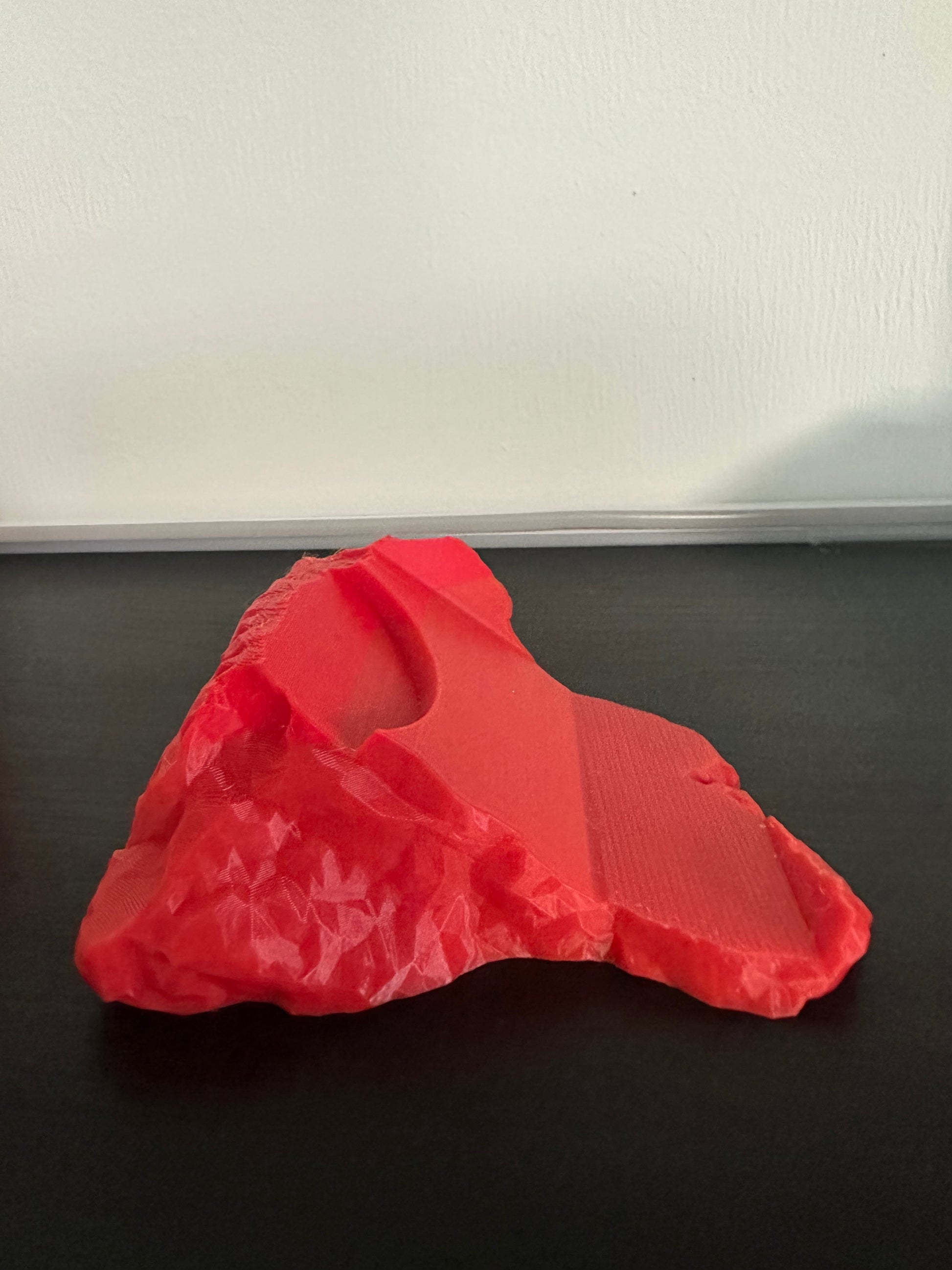 3D-printed red Thor hammer base on a black background
